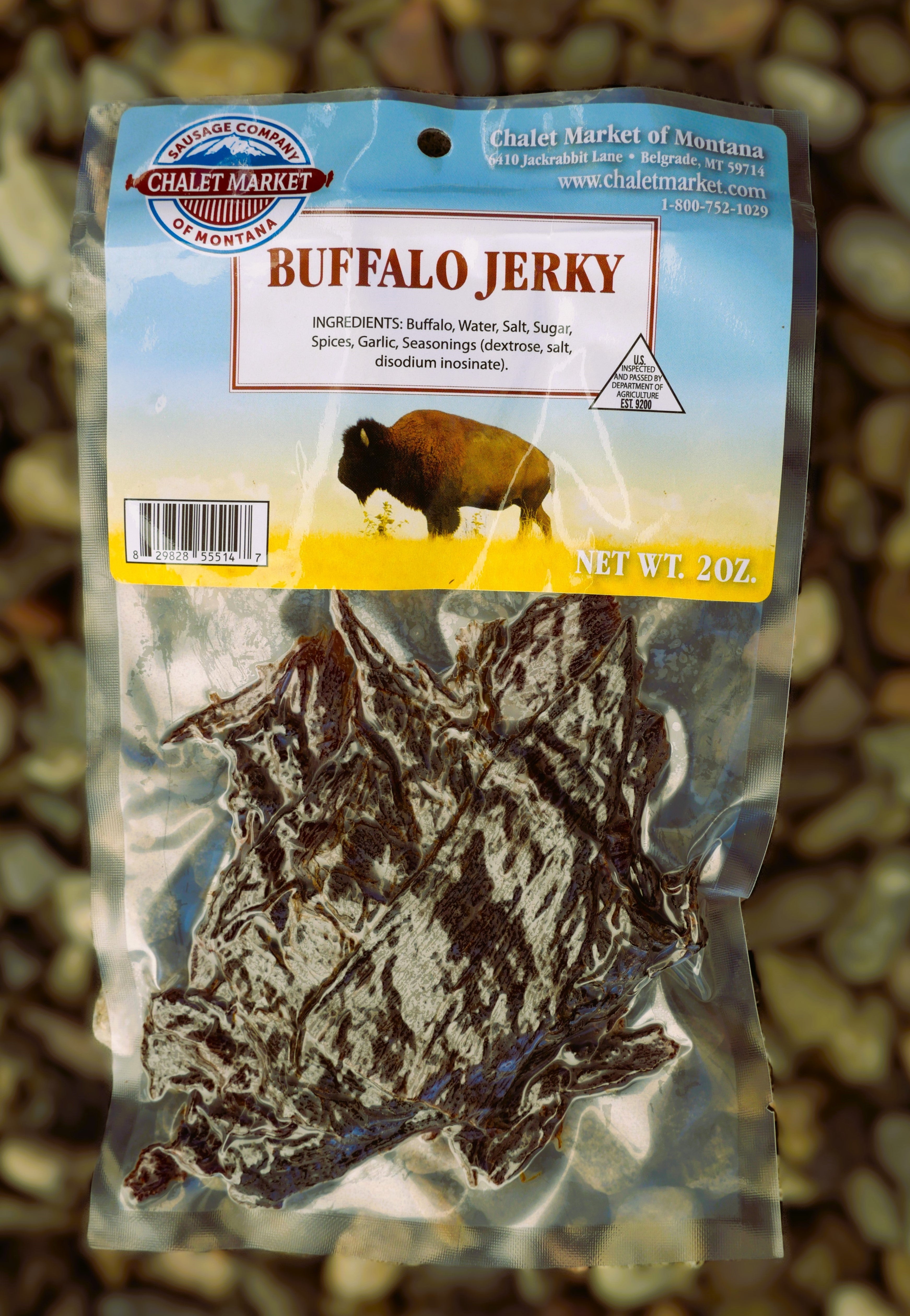 A 2 oz bag of Chalet Market of Montana Buffalo Jerky, showing the dark brown cured jerky slices inside a clear plastic bag with a printed header card featuring a bison graphic.