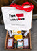 A curated gift box filled with gourmet snacks and meats, featuring a white tote bag printed with 'From Utah with Love' and red handles, set in a cardboard box with shredded filler.