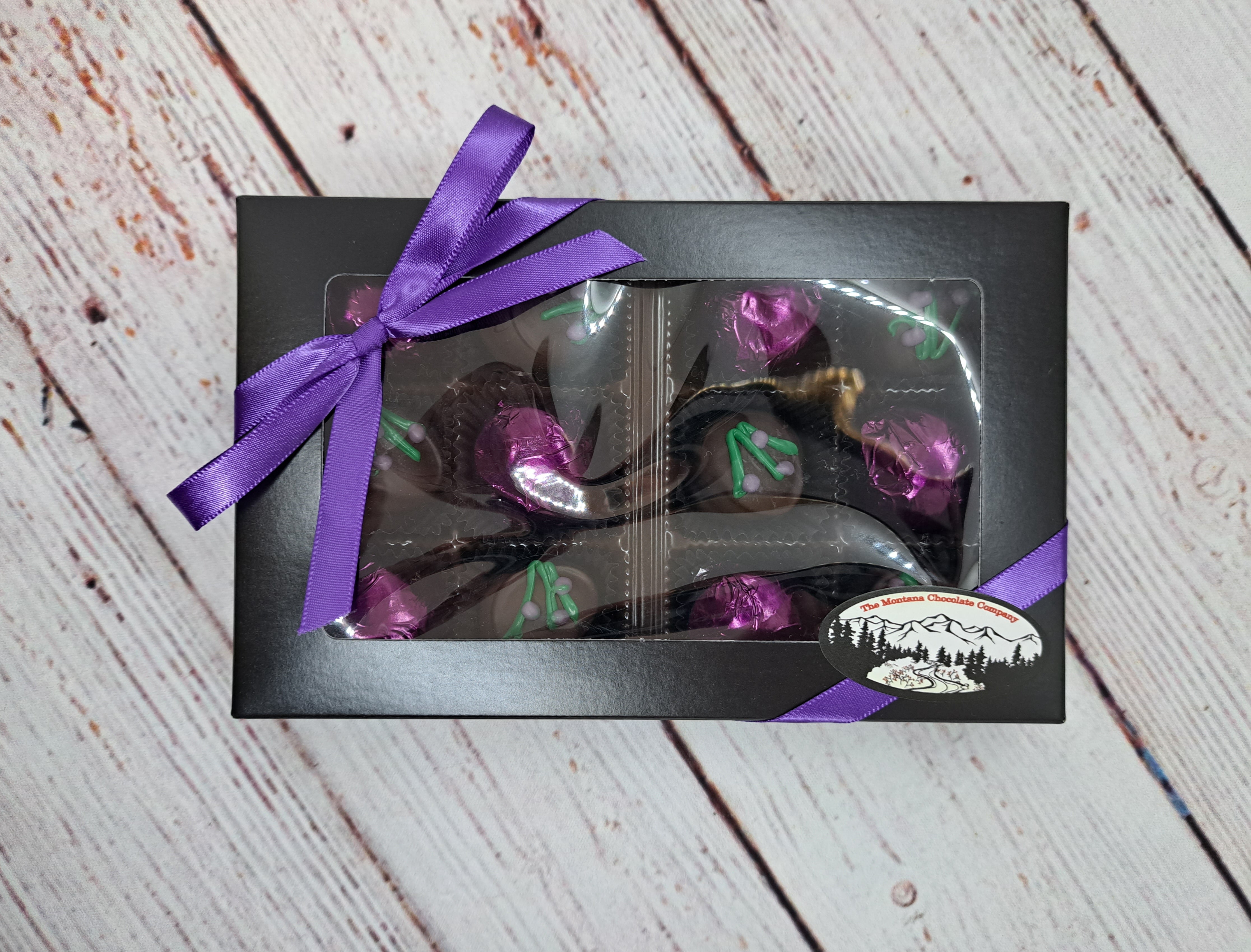 The Montana Chocolate Company Chocolate Huckleberry Swoons, 12pc Huckleberry Includes an equal number milk, dark and white chocolates  Hand-crafted in Stevensville, MT 12-piece collection, Black Box with Purple Ribbon 