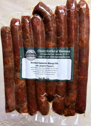 A vacuum-sealed package of smoked habanero mango stick with jalapeño peppers from Chalet Market of Montana, showing multiple reddish-brown cured sticks inside clear plastic packaging with a white and green label.